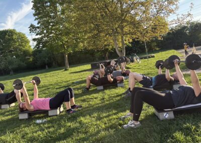 Langhantelgruppe macht Chestpress im Liegen