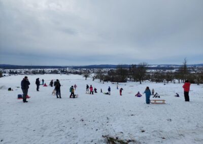 Viele Kinder am Rodeln auf dem Bergkopp