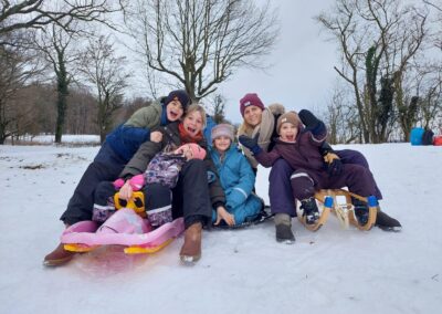Kinder und Eltern auf Schlitten