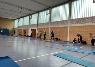 Turnhalle mit Personen beim Body Fit im Stehen