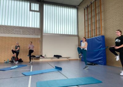 Turnhalle mit Personen beim Body Fit im Stehen