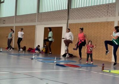 Turnhalle mit Personen beim Body Fit im Stehen