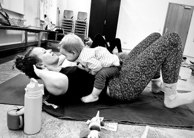 Sport auf der Matte mit Baby auf dem Bauch