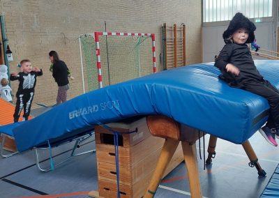 Kinder turnen an einer Station mit Weichboden