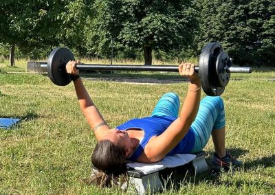 Trainerin im Brusttraining mit Langhantel